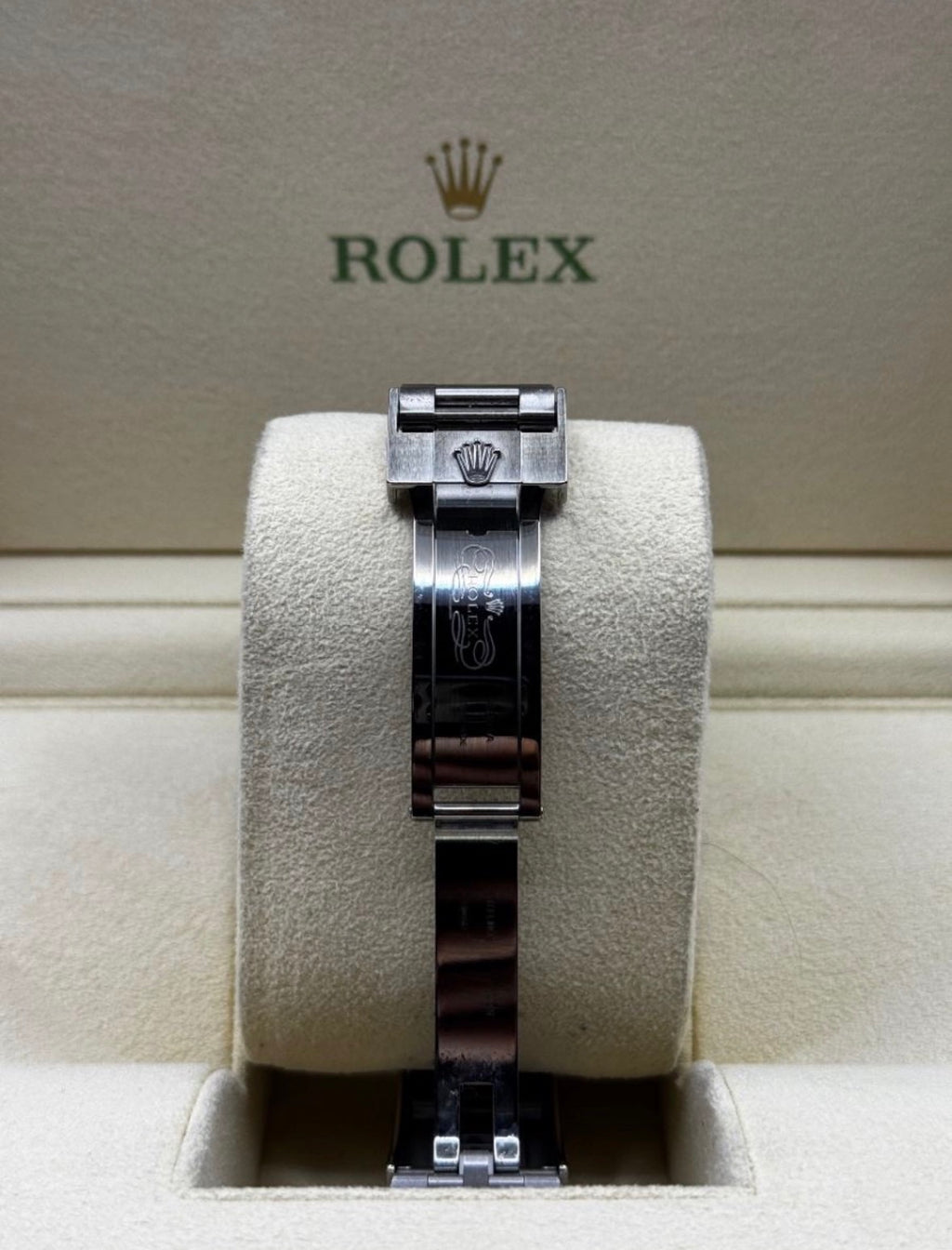 Rolex watch on a display stand with the Rolex logo in the background