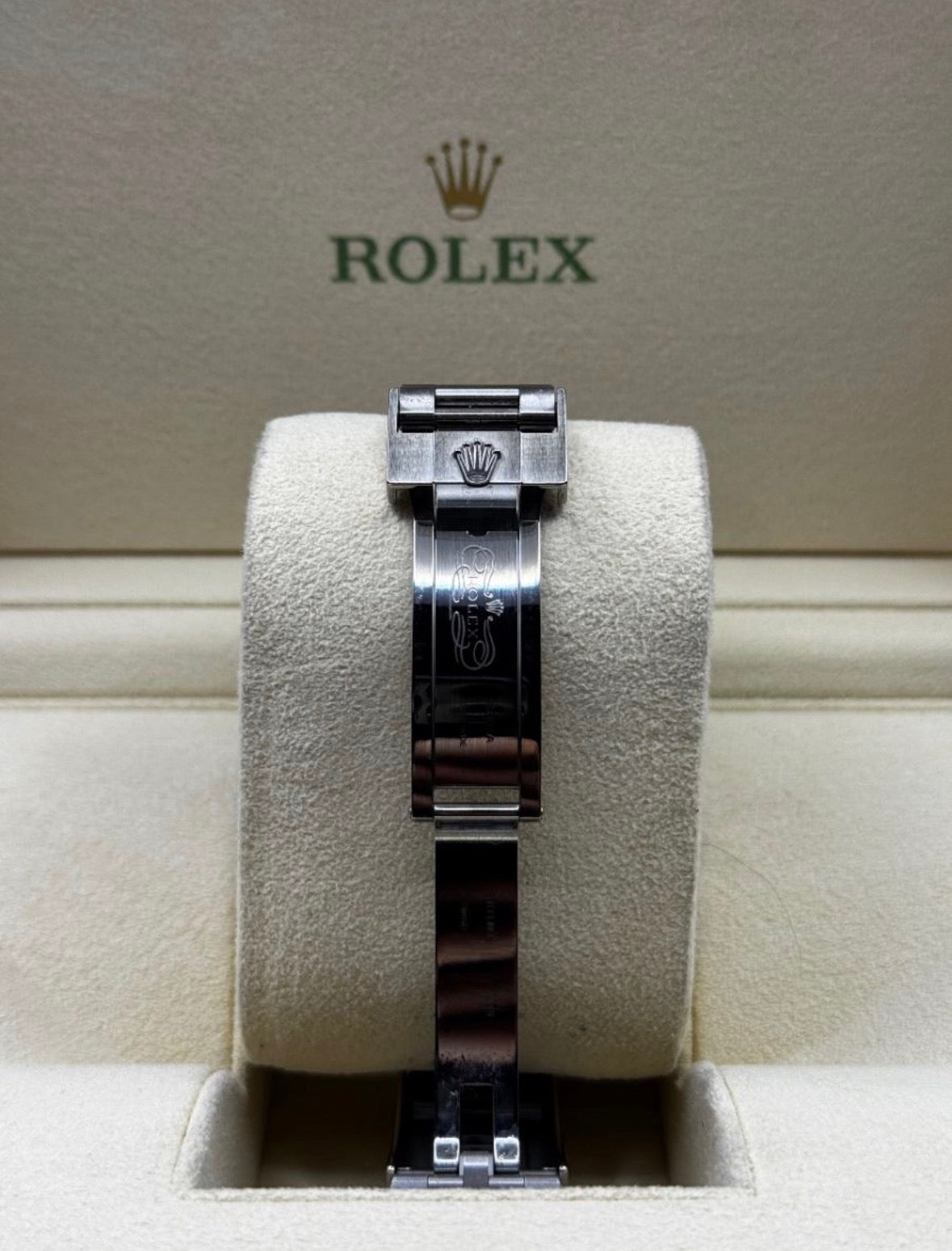 Rolex watch on a display stand with the Rolex logo in the background