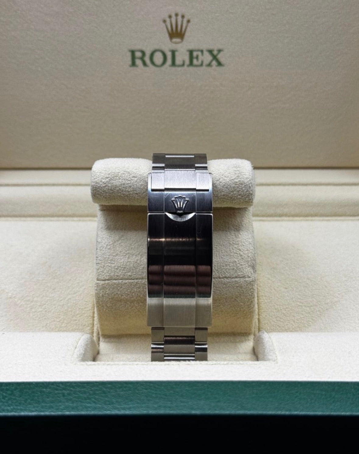 Rolex watch on display with the brand logo in the background