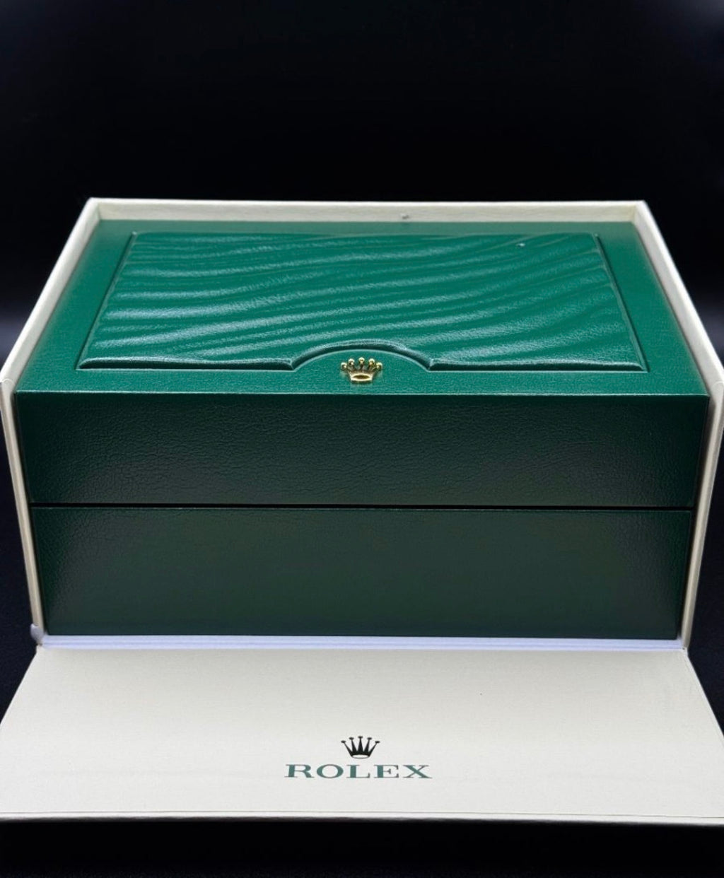 Green Rolex watch box on a black background