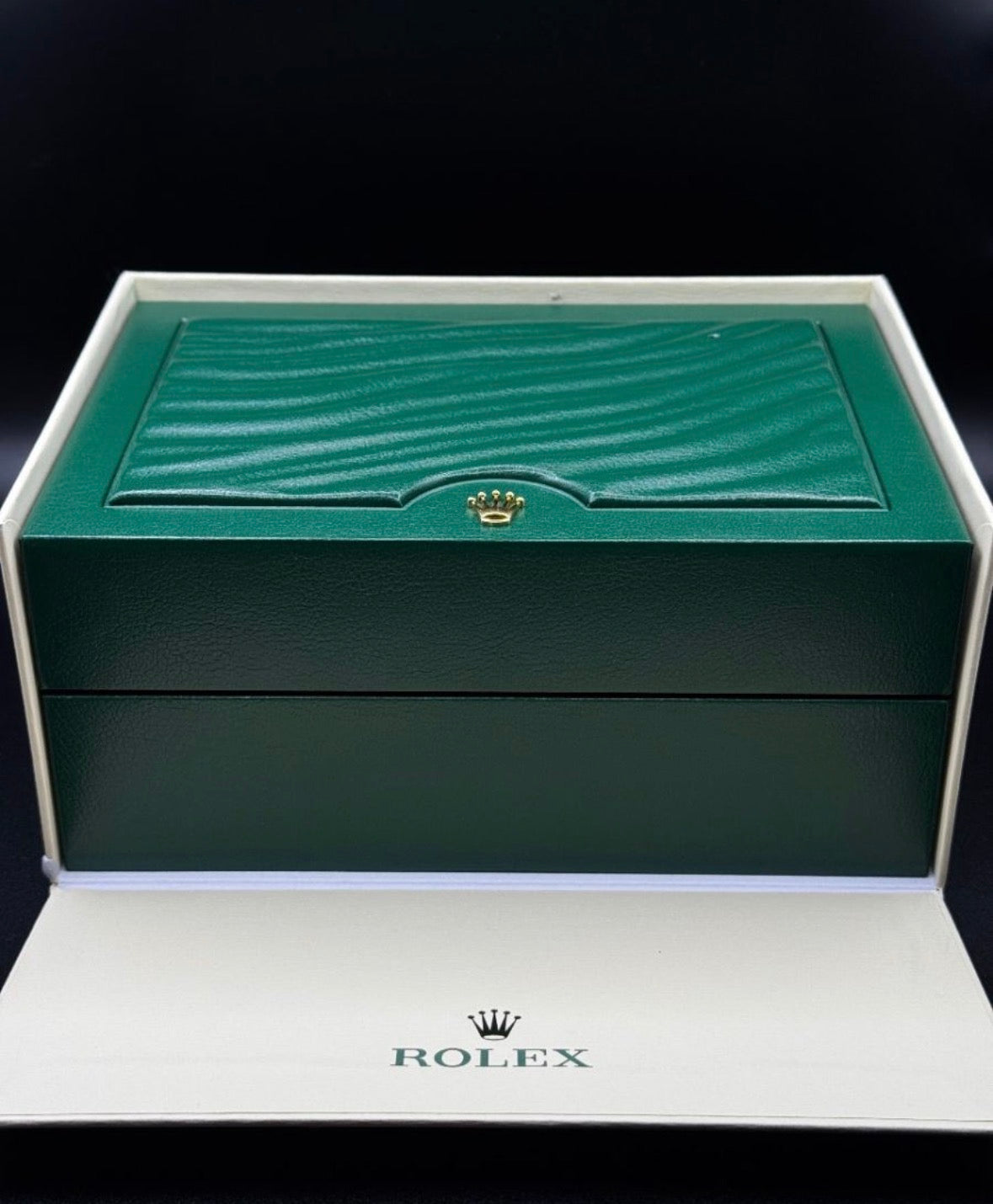 Green Rolex watch box on a black background